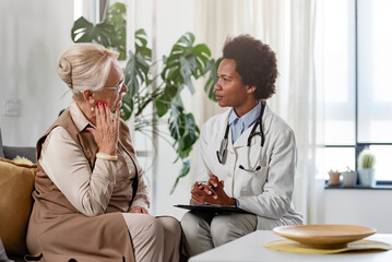 Wall Mural - Doctor specialist consulting a patient at the clinic. A female doctor is talking with a female elderly patient.