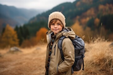 Wall Mural - Happy boy with backpack hiking in autumn mountains. Travel and adventure concept.