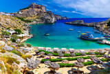 Fototapeta Morze - Lindos city on Rhodes island, Greece. St Paul's Bay Beach and the Acropolis, on Rhodos Island, Greece at Aegean Sea
