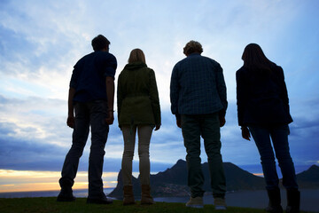 Canvas Print - Friends, back of people and silhouette for travel, hiking in nature with view and sunrise sky while outdoor. Clouds, natural and environment, trekking for adventure and bonding with friendship