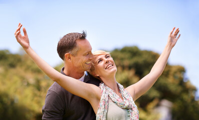 Canvas Print - Couple, freedom and smile with love outdoors for honeymoon vacation, together and arms up for happiness. Man, woman and relationship with care for romance, marriage and support with trust for bonding