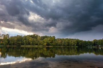 Wall Mural - Natural landscape of the lake, high definition, the movement of waves against the background of the autumn forest. The reflection of clouds on the ripples of water. Germany.