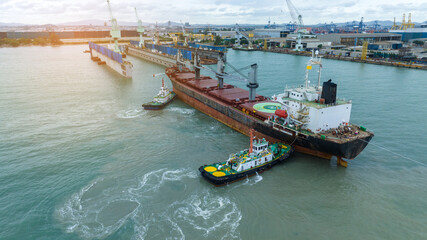 Tug boat pulling cargo container ship to dry dock concept maintenance service working in the sea. Insurance and Maintenance Cargo Ship concept. Freight Forwarding Service maintenance Insurance