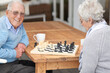 © peopleimages.com - Happy, game and senior couple with chess together in retirement to relax on holiday or vacation. Elderly, man and woman outdoor with smile for winning competition, checkmate or activity with strategy