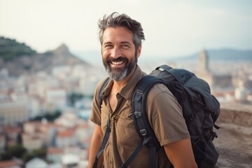 Wall Mural - Portrait of a smiling man with backpack on top of a hill