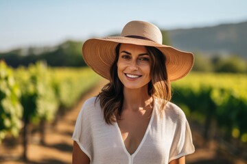 Wall Mural - Portrait of a beautiful woman in a hat in a vineyard