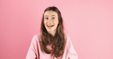 Brunette Woman Call Someone Hold Hand Near Mouth And Point Finger On Side, Laughing Isolated On Pink Background. Hey You Look Here!