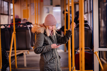 Wall Mural - Smiling Young Woman Texting on Phone During Bus Journey