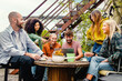 © Lomb - Diverse group of friends sharing ideas over coffee on a rooftop garden - Blending work and leisure in an urban setting
