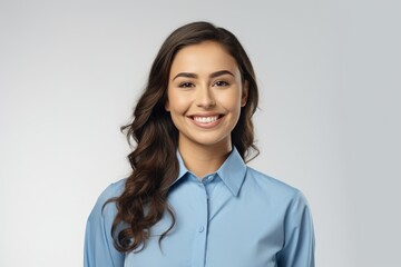 Wall Mural - A woman in a blue shirt smiling at the camera. Suitable for various uses