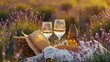 Two glasses with white wine and bottle on background of a lavender field. Straw hat and basket with flowers lavender on a blanket on picnic. Romantic evening in sunset rays. Summer in Provence