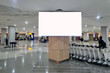 © Andri - An empty billboard in a crowded airport with a trolley cart in the background. Public space blank LCD screen template