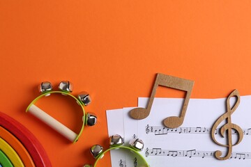 Sticker - Tools for creating baby songs. Flat lay composition with tambourines for kids on orange background. Space for text