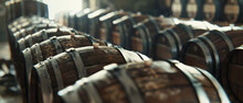 Rows of aged wine barrels rest in the dim light, capturing the timeless art of winemaking
