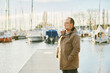 Outdoor portrait of happy mature man enjoying nice cold day by the lake or see