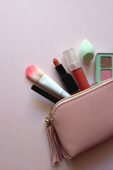 Wall Mural - Pink make up bag with various beauty products. Pink background, top view.