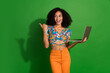© deagreez - Photo of young excited positive girl holding macbook pro 15 point finger empty space download update ios isolated on green color background