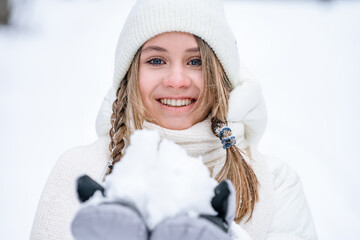 Wall Mural - Beautiful Caucasian girl with pigtails in a white coat in winter in the forest, portrait of a young girl