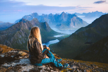 Wall Mural - Solo traveler enjoying landscape in Norway Lofoten islands aerial view woman traveling outdoor relaxing on the top of mountain alone healthy lifestyle summer vacations adventure trip