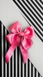 A delicate pink bow against a black and white striped background adds a touch of softness to this classic composition. Pink bow with a charming feel.