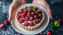 Top-view of hands holding a beautiful white chocolate pie with cream and raspberries 
