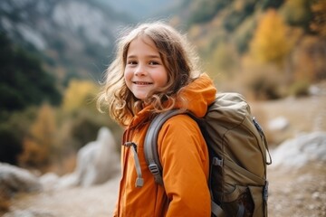 Wall Mural - Adorable little girl with backpack hiking in autumn mountains. Outdoor portrait