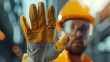 © MP Studio - close-up of a worker in safety gear extending a gloved hand in a stop gesture.
