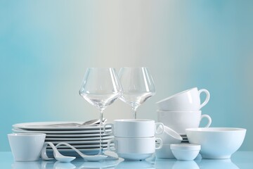 Sticker - Set of many clean dishware and glasses on light blue table