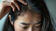© Viktorikus - Worried Young Asian Woman Checking Her Hair for Signs of Thinning