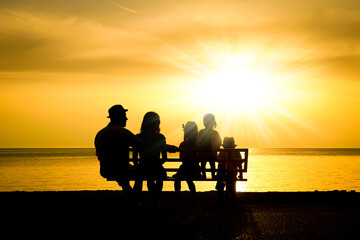 Wall Mural - A happy family in nature by the sea on a trip silhouette