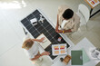 © DragonImages - Manager helping house owner to decide hos many solar panels he needs, top view