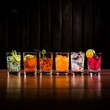 A variety of cocktails on a wooden bar