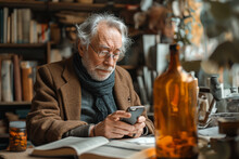 Senior man using smart phone while sitting with diary and medicines on table at home