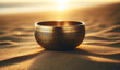 Golden singing bowl placed gently in the sand. Sound therapy with empty golden bowl during surise.