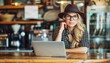 © Ilja - Freelancer woman in cafe with wireless headphones and laptop, creating a cozy work environment.