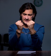 Sticker - Young convict man sitting in dark room