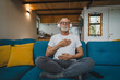 © Miljan Živković - One senior man doing guided meditation yoga self care practice at home
