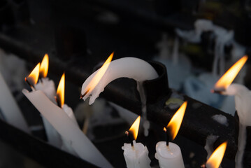 Several lit candles burning during the day. Concept of religiosity.