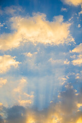 Wall Mural - Sun rays through clouds in the blue sky. Nature background. Selective focus.