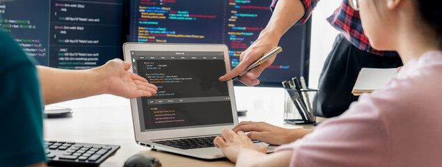 Two smart cooperative computer engineers working together as teamwork to solve program code while computer screen displayed program code. Laptop, web development, programer, java script . Burgeoning.