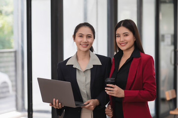 Wall Mural - Young professional business woman working together with laptop while standing in the office room.