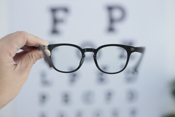 Hand holding glasses in clinic 