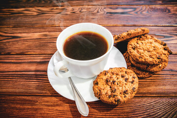 Wall Mural - A cup of hot coffee stands on a wooden table
