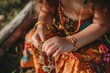 child in a hippie dress playing with boho charm bracelet