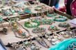 bohothemed jewelry display on a flea market table with a person browsing
