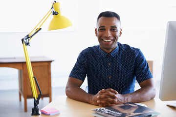 Young businessman, portrait and happy in office by desk, consultant and creative in career. Smile, black man or positive face of journalist in co working space or professional for ambition in company