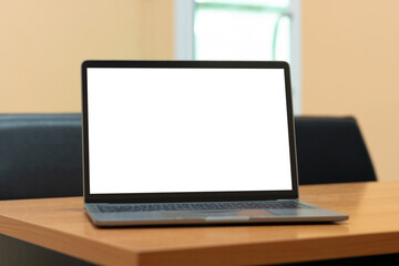 Laptop computer with white blank screen on wood desk. Workspace, workplace, desktop office concept.