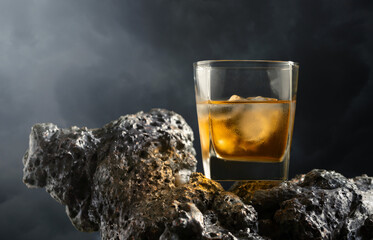 Poster - Whiskey with ice on a grey stone.