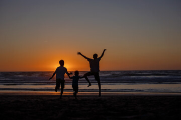 Sticker - Happy children, boys, playing on the beach on sunset, kid cover in sand, smiling, laughing