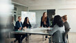 © Flamingo Images - Smiling executive and a group of businesswomen talking during a boardroom presentation